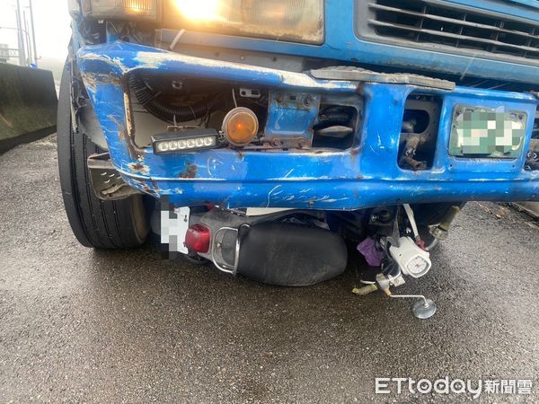 ▲載運飼料大貨車轉彎進支線道路時，機車衝撞貨車後鑽進車底，騎士大腿骨折送醫。（圖／記者楊永盛翻攝）