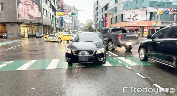 ▲桃園市中壢區延平與元化路處5日上午發生轎車左轉未禮讓行人事故，肇事黑色轎車等待員警處理。（圖／記者沈繼昌翻攝）