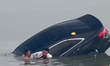 ▲▼駕駛連人帶車墜湖　英勇男「口咬撬棍」跳冰冷湖水砸窗救援。（圖／翻攝自微博）