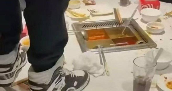 大陸網路上近日瘋傳1段影片，只見1名男性在海底撈火鍋店用餐後，竟站在桌上往鍋底撒尿。（圖／翻攝自微博）