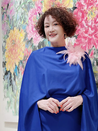 ▲韓湘琴一襲寶藍套裝（中）開畫展，全家總動員。右二：唐威。左二：唐志中。 左五：唐可珊。（圖／韓湘琴提供）