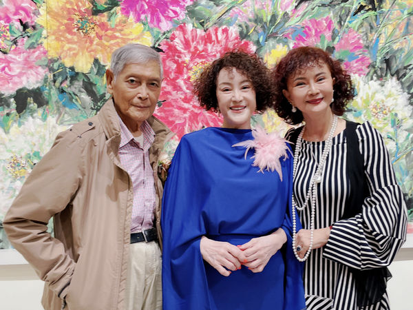 ▲韓湘琴一襲寶藍套裝（中）開畫展，全家總動員。右二：唐威。左二：唐志中。 左五：唐可珊。（圖／韓湘琴提供）