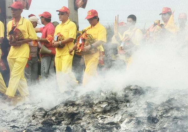 ▲桃園市竹圍福海宮每輔信王公誕辰慶典，信眾手捧神尊打赤腳走過金紙火堆。（資料照／福海宮提供）