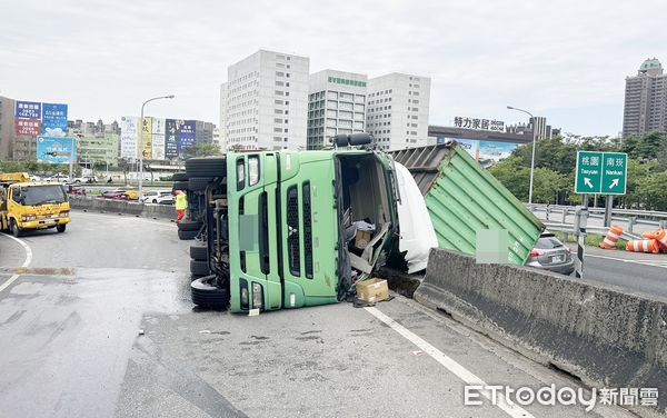 ▲一輛貨櫃車今天上午11時許行經國道1號桃園交流道南向環向匝道入口處時，突然失控側翻，國道警方到場處理。（圖／翻攝自國道即時路況）