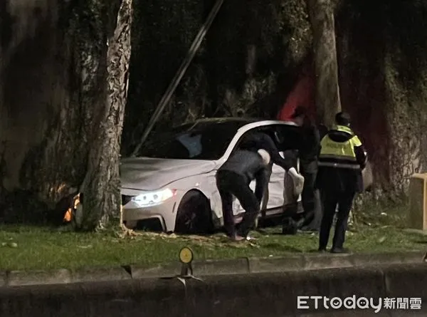 ▲▼北市中山區樂群一路有1台BMW轎車，衝進路邊草皮卡在防波圍牆、樹木中間。（圖／記者讀者提供）