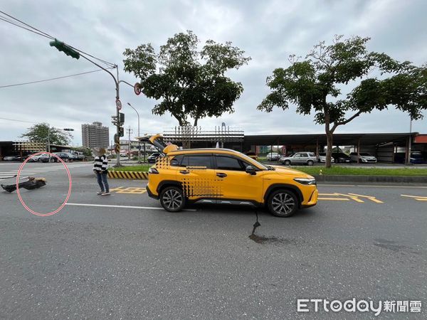 ▲▼黃狗兒（圓圈處）與計程車相撞受傷躺地上，計程車黑色輪胎護板也被撞落。（圖／記者游芳男翻攝，下同）