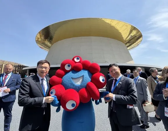 ▲2025大阪世博在大阪市的夢洲會場「夏恩帽」（Shining Hat)舉行開幕式，會長黃志芳（左）和TECH WORLD館館長邱揮立（右）代表出席，與大會吉祥物脈脈合影。（圖／貿協提供）