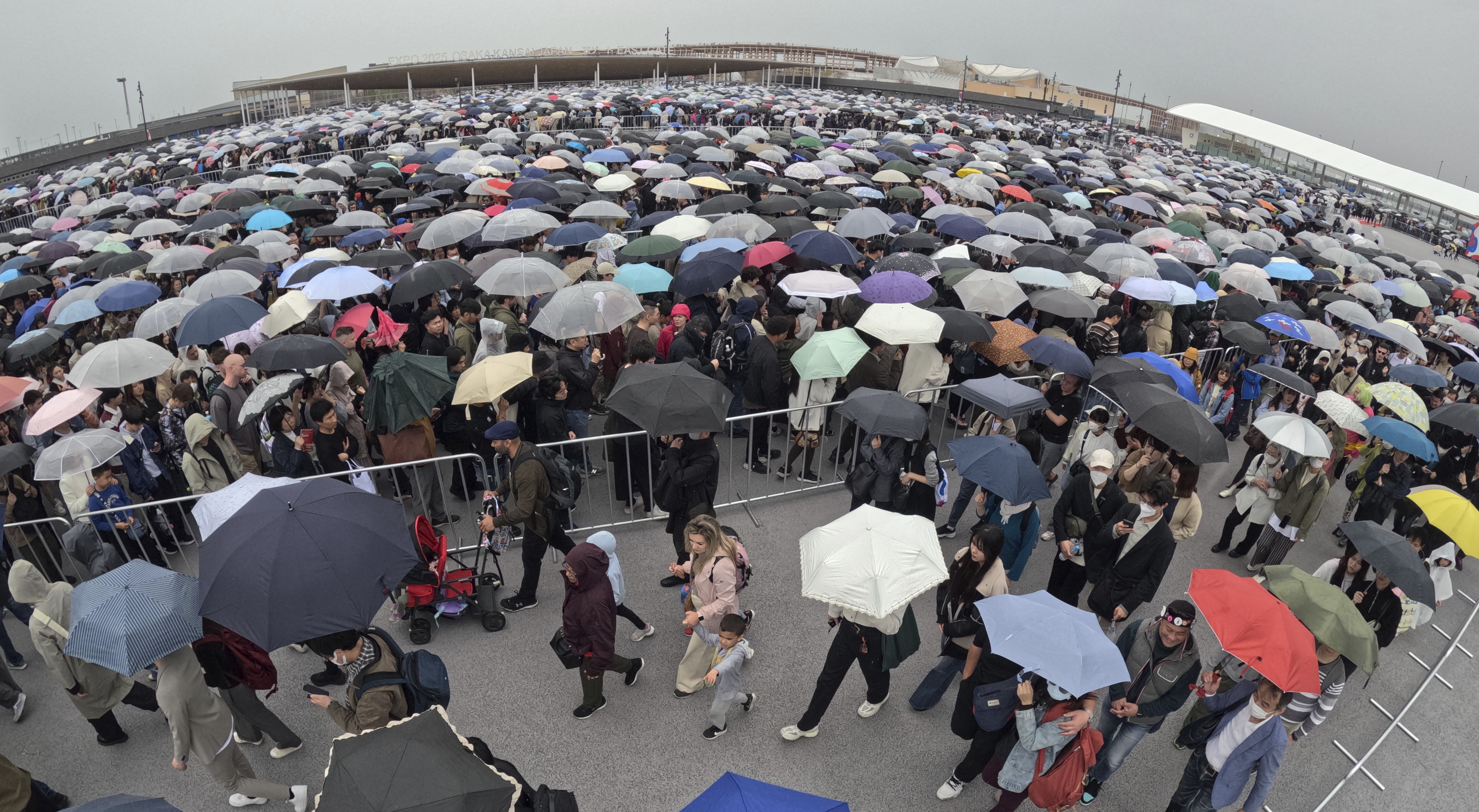 ▲▼2025大阪世博開幕13日第一天下起大雨，民眾狼狽撐傘排隊進場。（圖／達志影像／美聯社）