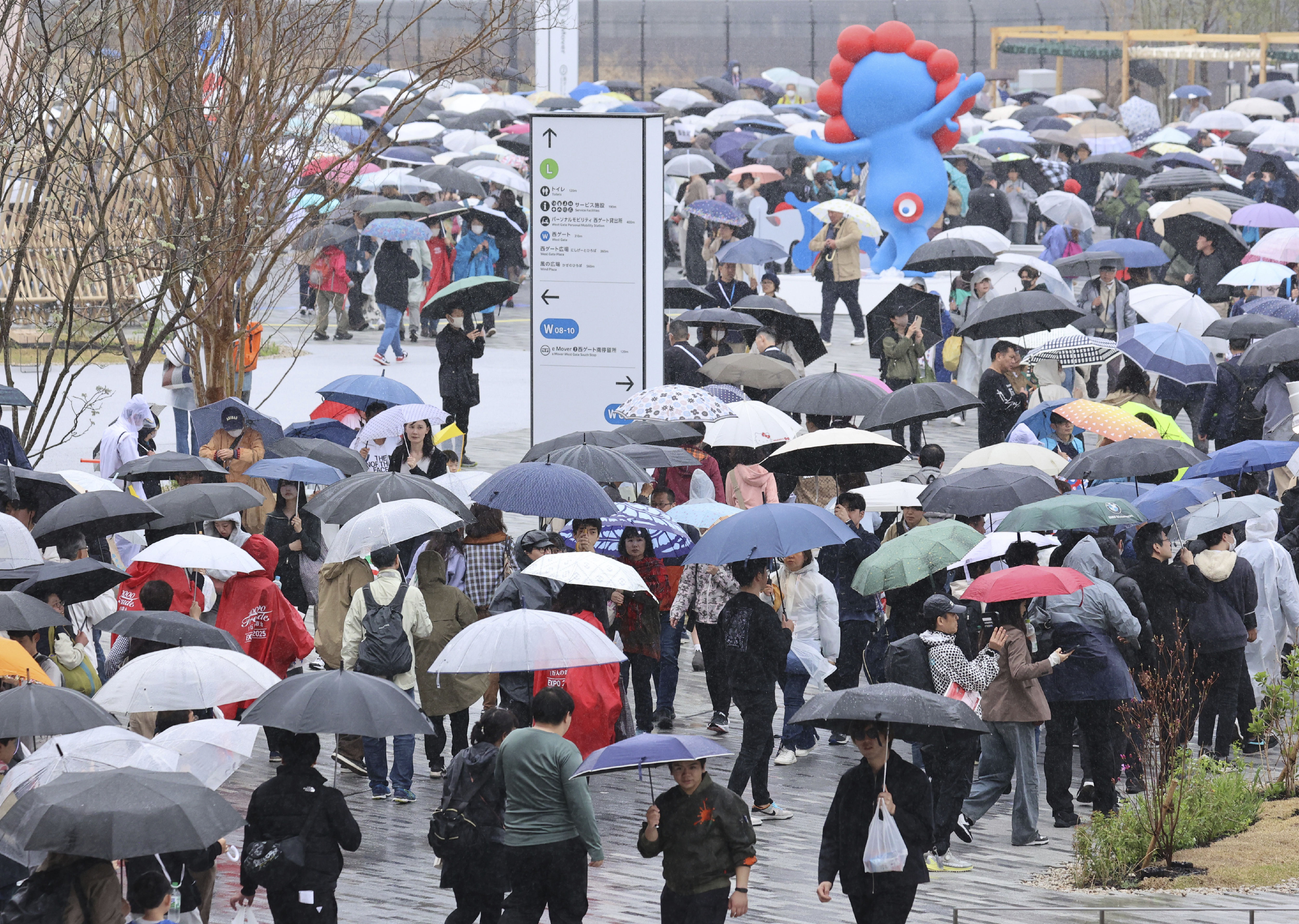 ▲▼2025大阪世博開幕13日第一天下起大雨，民眾狼狽撐傘排隊進場。（圖／達志影像／美聯社）