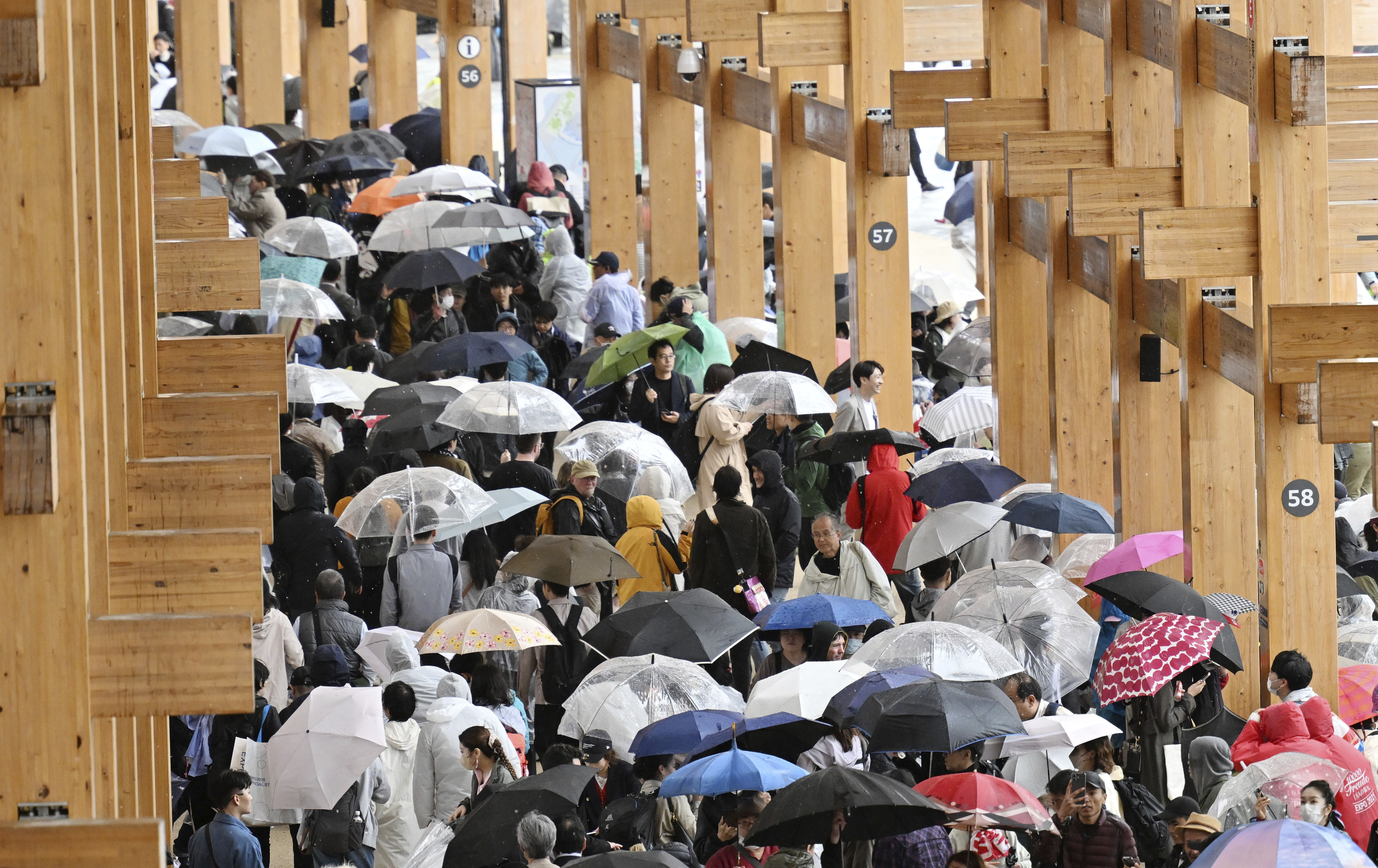 ▲▼2025大阪世博「大屋頂環」東側區域13日因大雨導致滲水，民眾持雨傘。（圖／達志影像／美聯社）