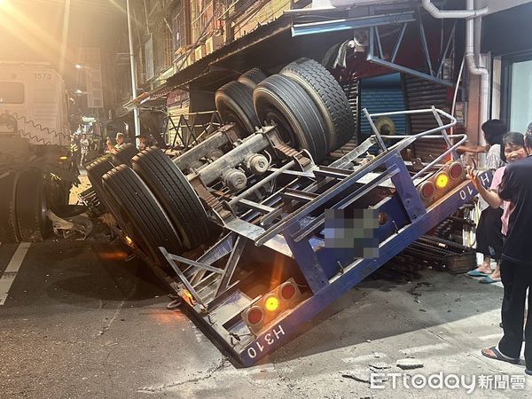 ▲雲林一輛載運鋼筋水泥柱的拖板車翻覆，水泥柱砸爛民宅鐵捲門。（圖／記者游瓊華翻攝，下同）