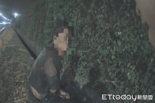 ▲外籍移工坐睡水溝，里港警分局新圍派出所警員呂佳賓、黃宏澤急忙叫醒          。（圖／記者陳崑福翻攝）