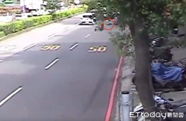 ▲▼拖吊業者掛在違規車輛右側輔助輪脫落，差點波及行經騎士，最後撞倒路旁的白色機車造成毀損             。（圖／記者陳以昇翻攝）