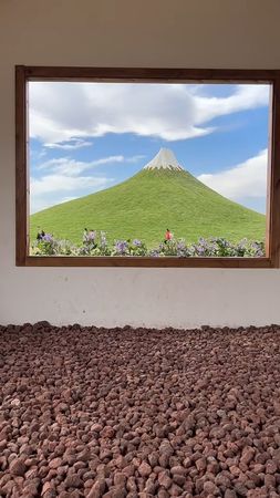 該樂園以人工草皮覆蓋山丘、白色塗料模擬雪頂，打造山寨日本富士山。（翻攝畫面）