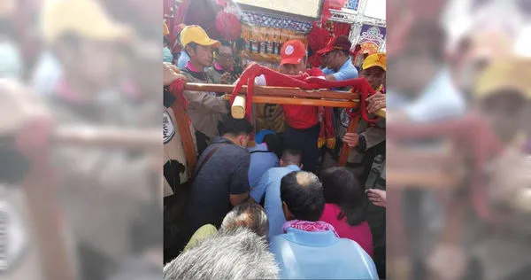 躦轎底時，不能起身或觸碰鑾轎，背包放在胸前，好讓鑾轎通過，不能戴帽子，要記得脫帽。（圖／楊登嵙提供）