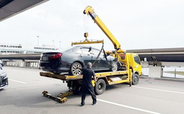 ▲桃園機場第一航廈今天下午發生排班計程車與租賃車碰撞3車連環碰撞事故，航警人員找來吊車將翻覆租賃車拖離現場。（圖／航警局提供）