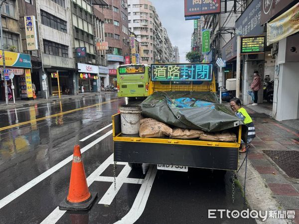 ▲▼公車行駛過停靠區時發生路面坍塌，出現一個大坑洞，新北市養工處已經用三角錐放置警示，待雨停後施工填補             。（圖／記者陳以昇翻攝）