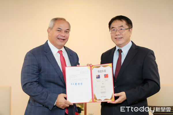 ▲台南市長黃偉哲致贈市鑰給澳洲黃金海岸市長泰特，象徵城市外交情誼歷久彌新。（記者林東良翻攝，下同）