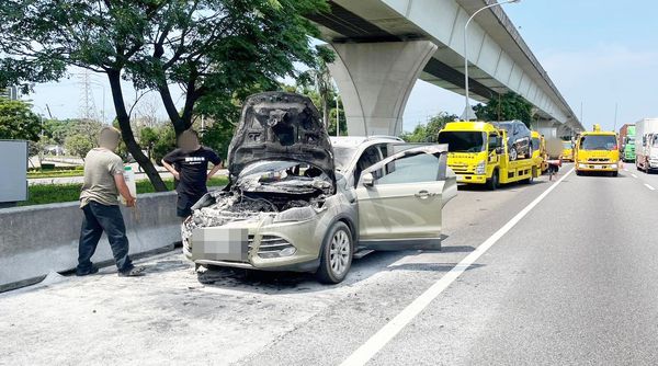 ▲國道1號中壢服務區路段今天下午發生故障車拖吊卻突然自燃意外，警消雖即撲滅火勢等候吊離現場。（圖／國道一隊提供）