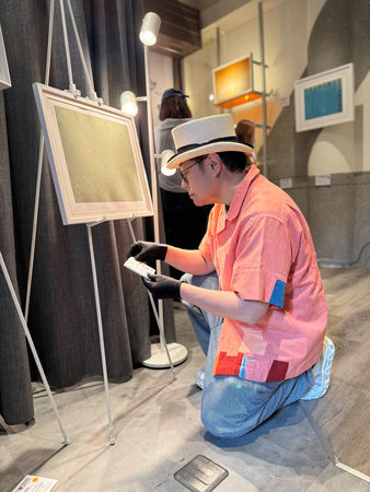 ▲蔡康永與潮洋行老闆Jin一起為畫展佈展，拿著蔡康永最新創作「如果」。（圖／潮洋行提供）