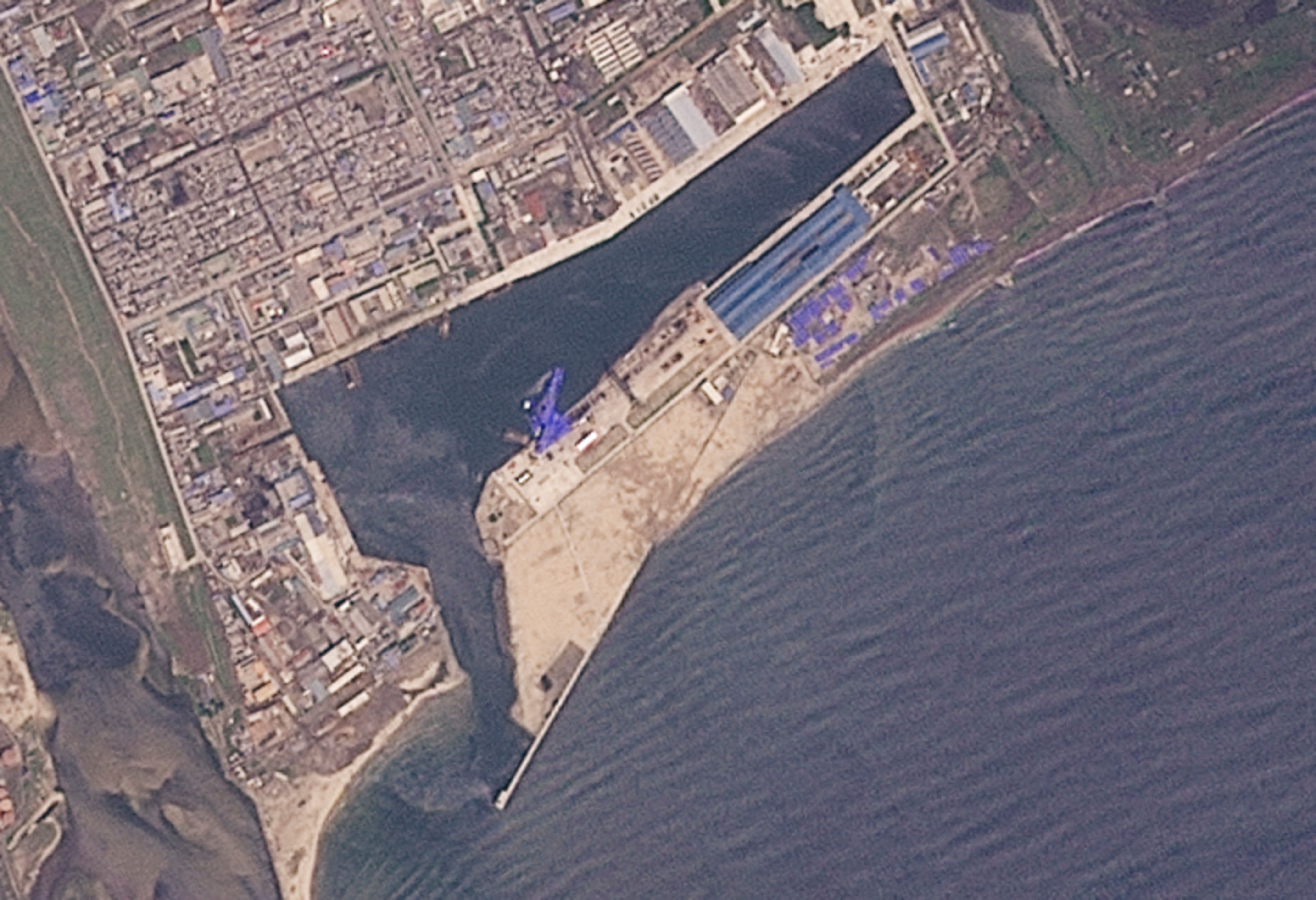 ▲▼北韓新型驅逐艦在清津下水時發生事故，船體覆蓋藍色防水布。（圖／路透）