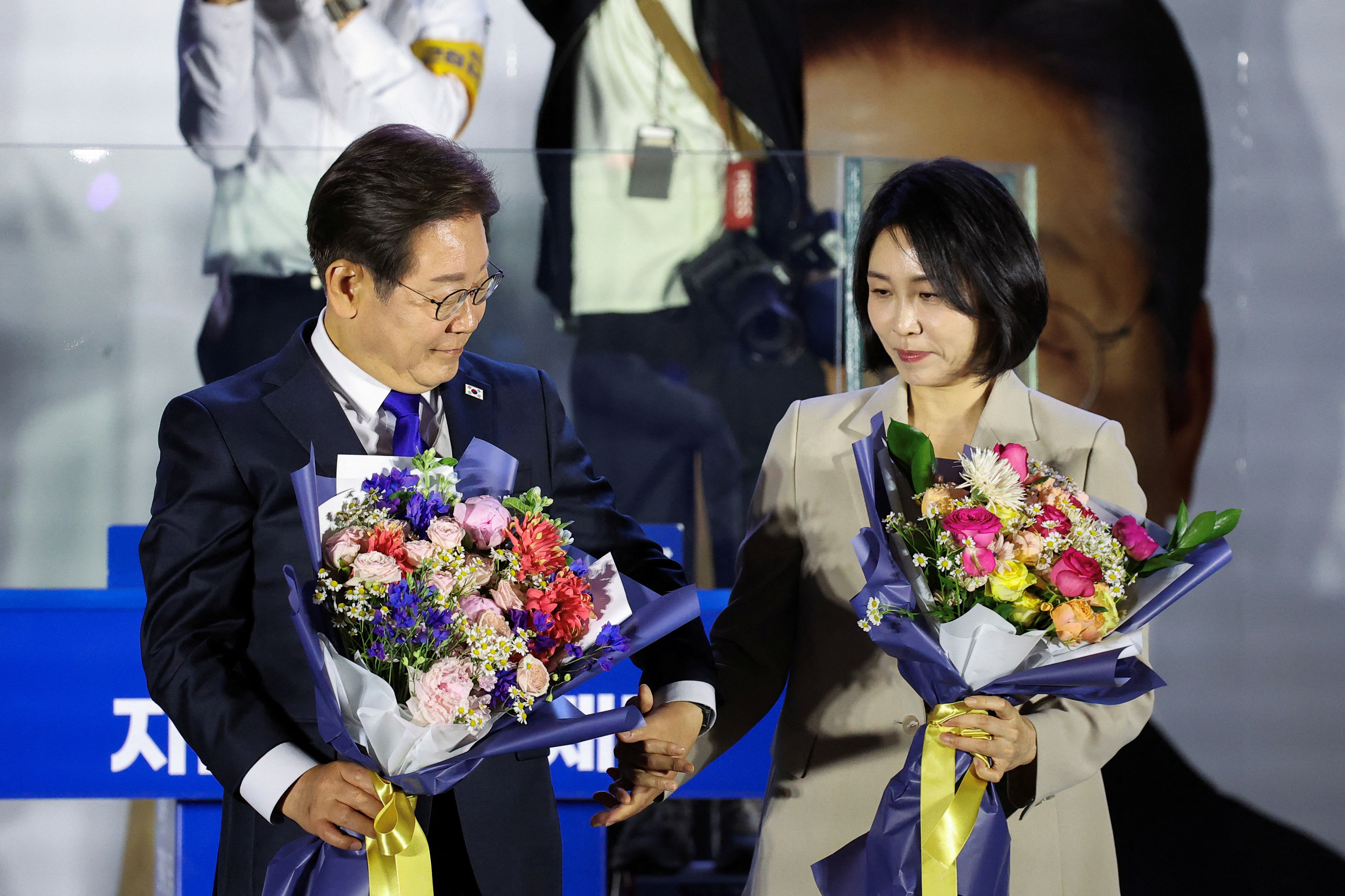 ▲▼南韓共同民主黨總統候選人李在明、金惠京接過花束，提早發表勝選感言。（圖／路透）
