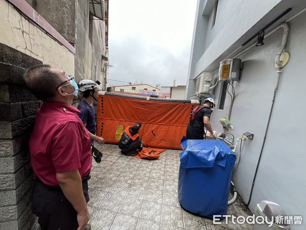 ▲竹山女子坐頂樓圍牆邊，消防人員緊急在一樓架設兩具小型氣墊。（圖／記者高堂堯翻攝）