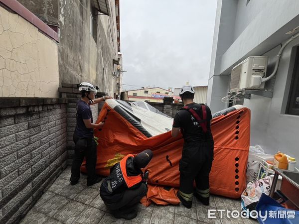 ▲竹山女子坐頂樓圍牆邊，消防人員緊急在一樓架設兩具小型氣墊。（圖／記者高堂堯翻攝）