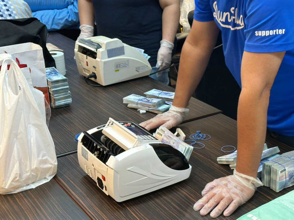 北市刑大逮獲洪姓父子檔，短短半年內至少騙得6千萬餘元，查獲現金至少2千萬餘元，警方還得出動點鈔機才能清算。（圖／翻攝畫面）