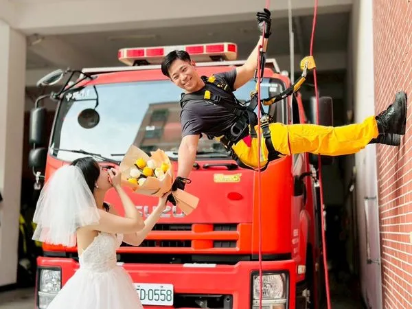 消防員黃偉哲利用休假時間到桃園中路分隊取景拍攝婚紗。（翻攝自桃園市政府消防局中路分隊臉書）