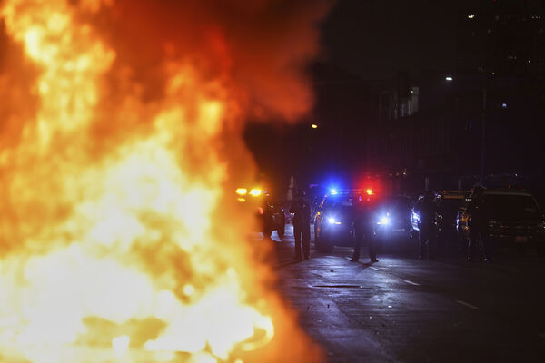 ▲▼美國洛杉磯，一輛汽車在警察的包圍下燃燒。（圖／達志影像／美聯社）