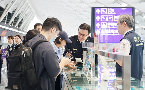▲移民署主任秘書林澤謙與移民署人員今天上午在桃園機場第一航廈向入境旅客說明入境新制各項措施。（圖／移民署提供）