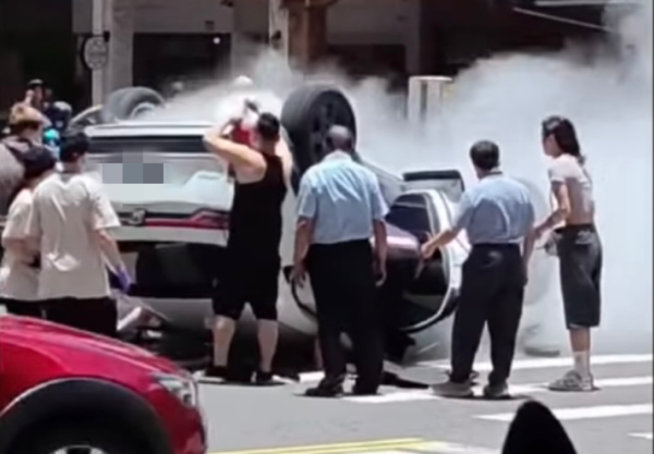 ▲ 高雄嚴重車禍！白車遭撞翻「躺地狂竄濃煙」，路人衝上前救援。（圖／翻攝自FB爆料公社）