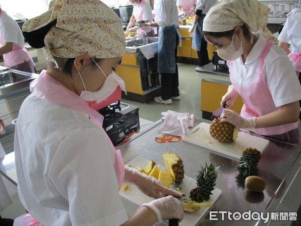 ▲日本北海道聖華高等學校學生手拿國旗開心品嘗來自台南的鳳梨，直呼「超甜超好吃」。（記者林東良翻攝，下同）