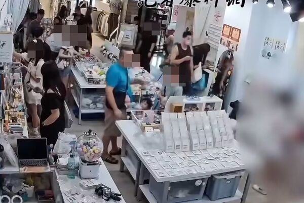 ▲▼1名身穿黑色背心的男子，趁短裙女店員蹲身找飾品，竟公然拍攝臉部和胸口，令人作噁。（圖／翻自記者爆料網）