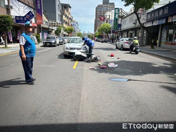 ▲苗栗市中華路發生轎車跟機車碰撞事故，女騎士腳踝卡轎車保桿內，熱心路人撐傘遮陽等待救護車。（圖／記者楊永盛翻攝）