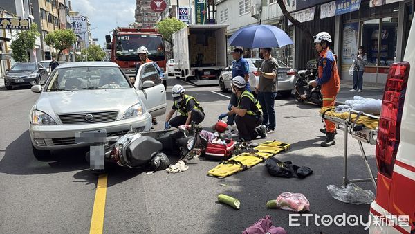 ▲苗栗市中華路發生轎車跟機車碰撞事故，女騎士腳踝卡轎車保桿內，熱心路人撐傘遮陽等待救護車。（圖／記者楊永盛翻攝）