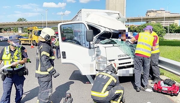 ▲國道2號大園交流道出口匝道昨天上午發生小貨車自撞護欄事故，員警與大園消防分隊人員到場處理，以破壞工具將林姓駕駛救出。（圖／大園消防分隊提供）