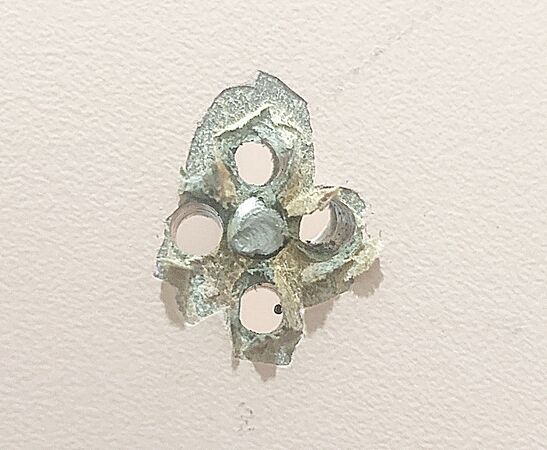 ▲有網友在通訊軟體上反映，桃園機場第二航廈登機門廁所發現疑似針孔攝影機，桃機公司從廁所另一面發現是掛勾孔洞漏補。（圖／桃機公司提供）