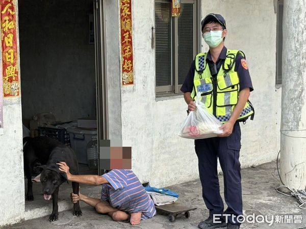 ▲潮州警分局新埤所警員傅奕銘助蘭男，蘭男坐在地上拉住狗腿。（圖／記者陳崑福翻攝）