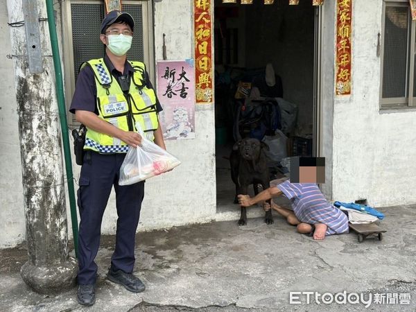 ▲潮州警分局新埤所警員傅奕銘助蘭男，蘭男坐在地上拉住狗腿。（圖／記者陳崑福翻攝）
