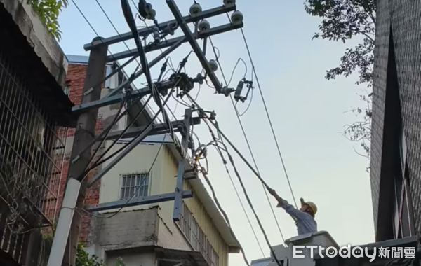 ▲台電搶修人員以長桿子將卡在電線桿上的松鼠移除。（圖／莊金泉里長提供）