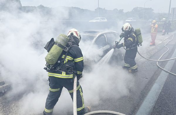 ▲國一北上桃園段今天上午11時38分一輛自小客車停靠避車彎後突然起火燃燒，桃園市消防局龜山分隊消防人員迅速撲滅火勢。（圖／國道一隊提供）