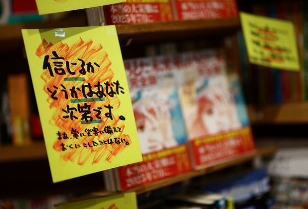 ▲漫畫《我所看見的未來》，店家張貼銷售標語寫著「信不信由你」 。（圖／路透）