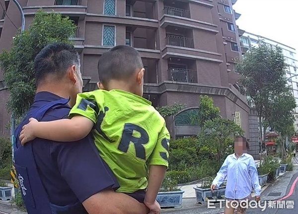 ▲員警抱著蘇小弟陪同她回家，經查證身分無誤將小朋友交還蘇太太。（圖／桃園警分局提供）