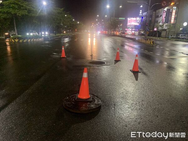 ▲員警合力將移位的人孔蓋搬回原處。（圖／記者游瓊華翻攝）