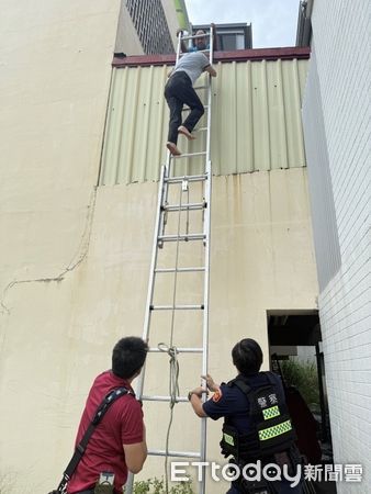 ▲台南市安平區一名婦人颱風前登樓巡視屋頂，不慎跌落至鐵皮屋受困，警消合力架梯救援脫困。（記者林東良翻攝，下同）