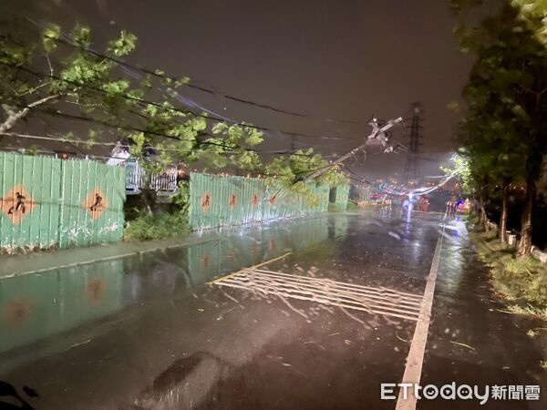 ▲台南市多處因丹娜絲颱風導致電線桿倒塌，工程人員正冒雨搶修中。（記者林東良翻攝，下同）