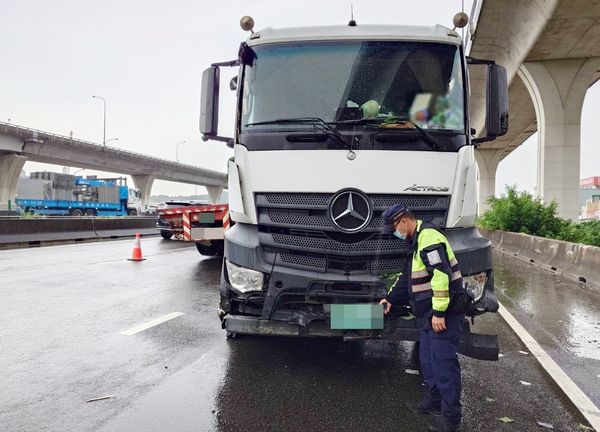 ▲國一桃園交流道入口匝道聯結車自撞護欄翻覆事故，警方動用大型吊車將聯結車拖出後，準備吊離現場。（圖／國道一隊提供）