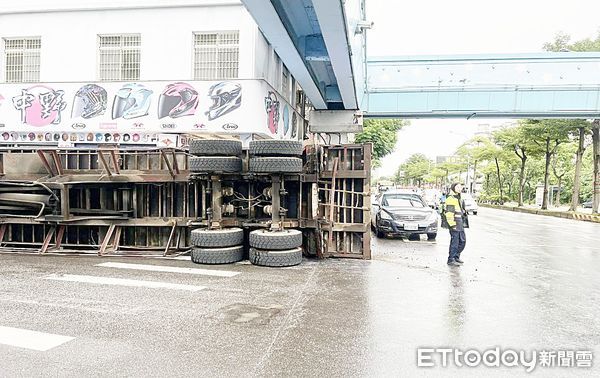 ▲一輛貨櫃車行經八德區中華路左轉龍壽街時，疑因速度過快失控翻覆，警方在路口進行交管。（圖／記者沈繼昌翻攝）